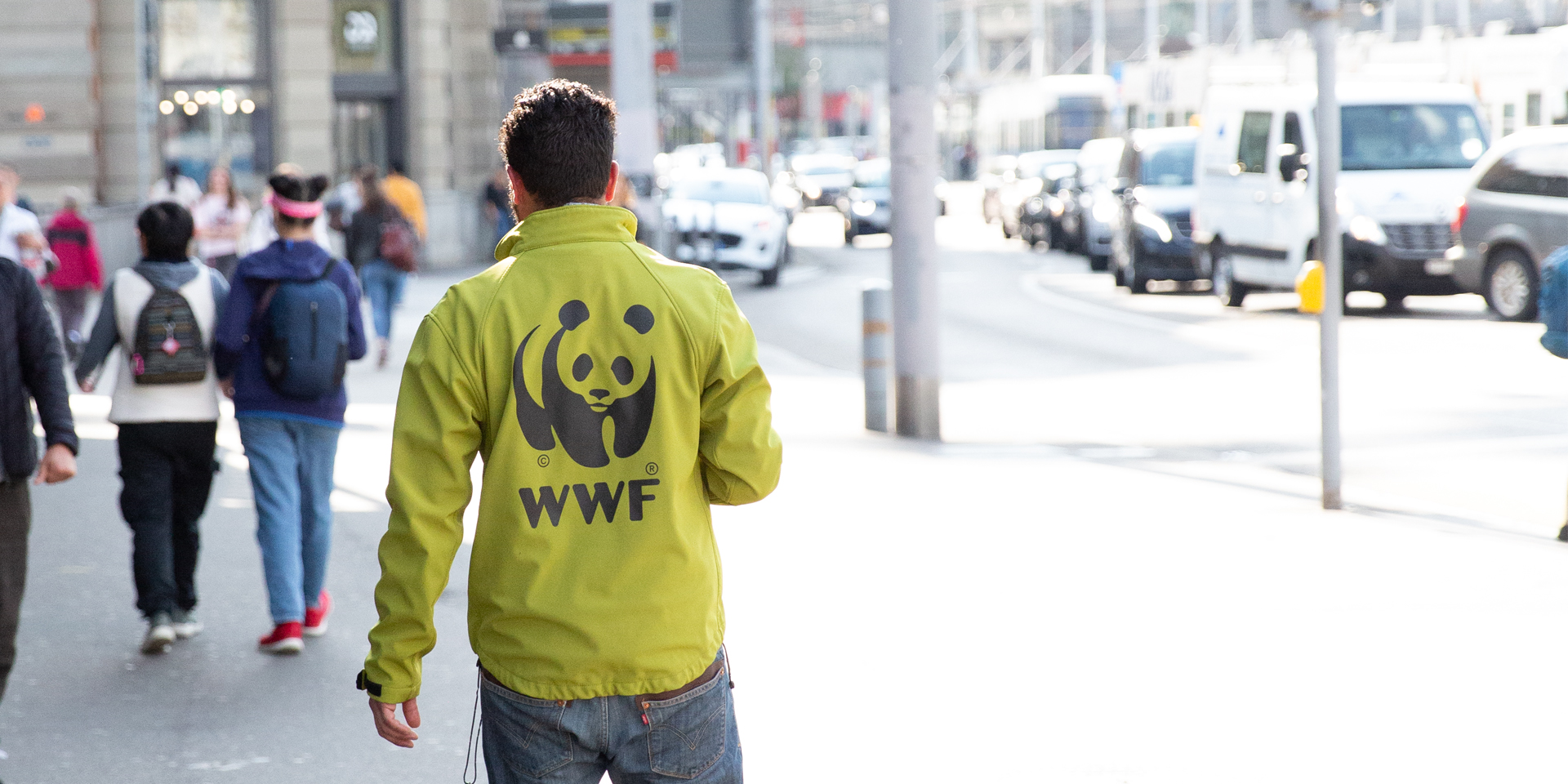 Junger Mann geht im Namen vom WWF auf Spender*innensuche in der Innenstadt